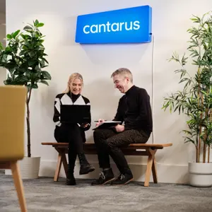 Two Cantarus developers chatting under neon sign