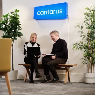Two Cantarus developers chatting under neon sign
