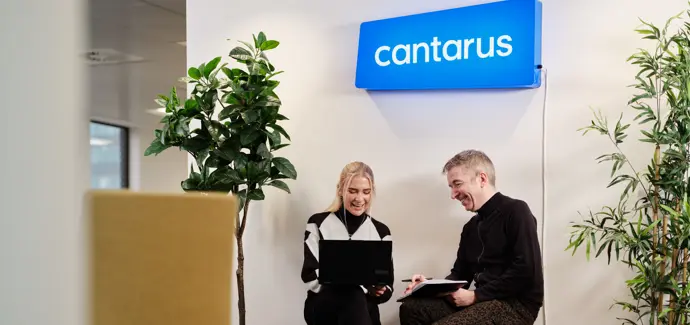 Two Cantarus developers chatting under neon sign