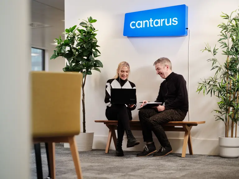 Two Cantarus developers chatting under neon sign