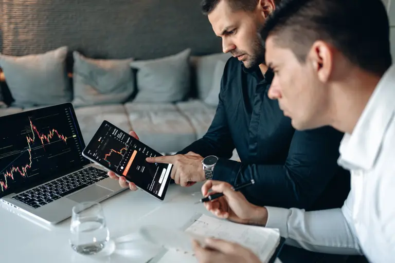 Two people working on tablet and laptop