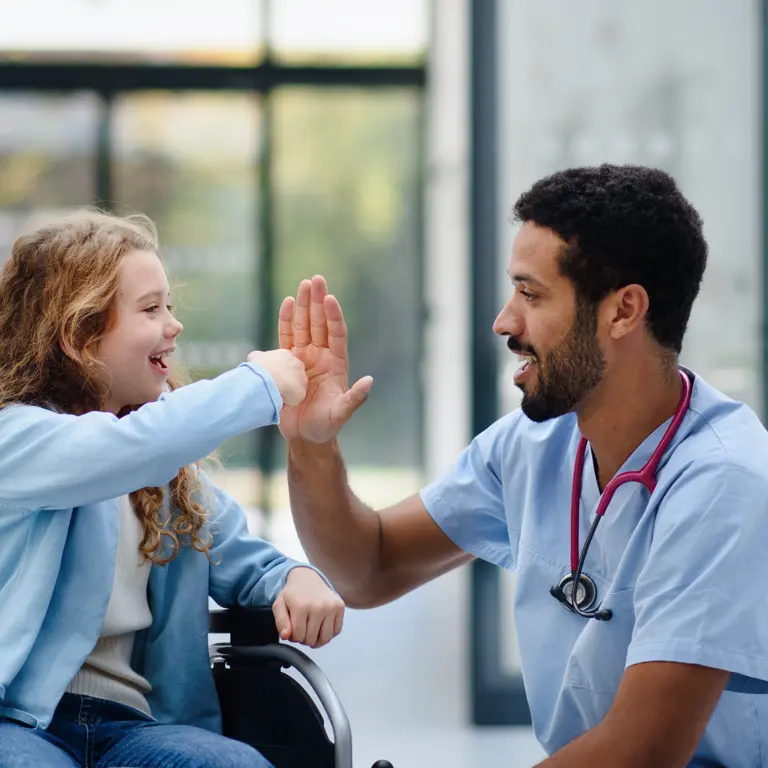 Young girl high fiving nurse