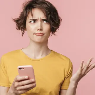a person holding a smartphone and expressing confusion