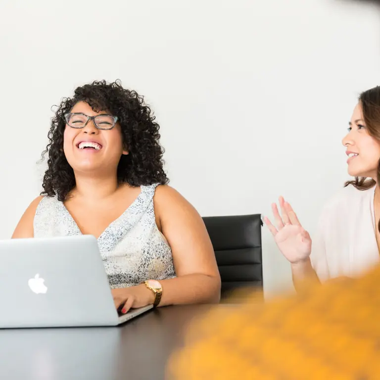 person laughing using a laptop