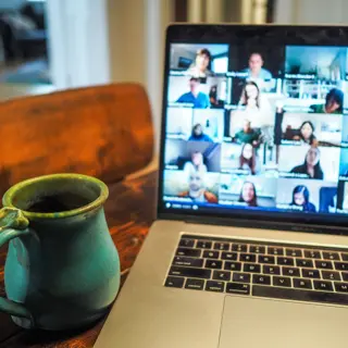 mug next to laptop video call screen