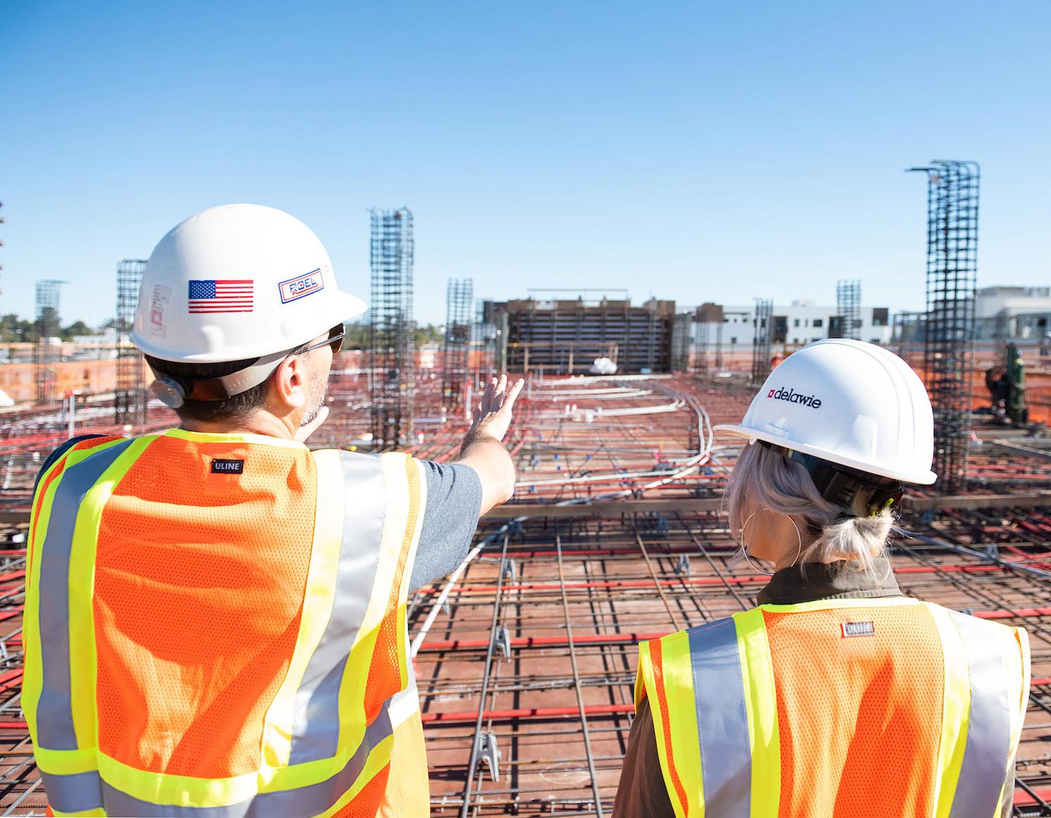 two people in hard hats surveying a construction site