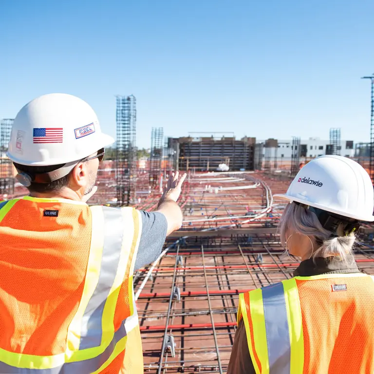 two people in hard hats surveying a construction site