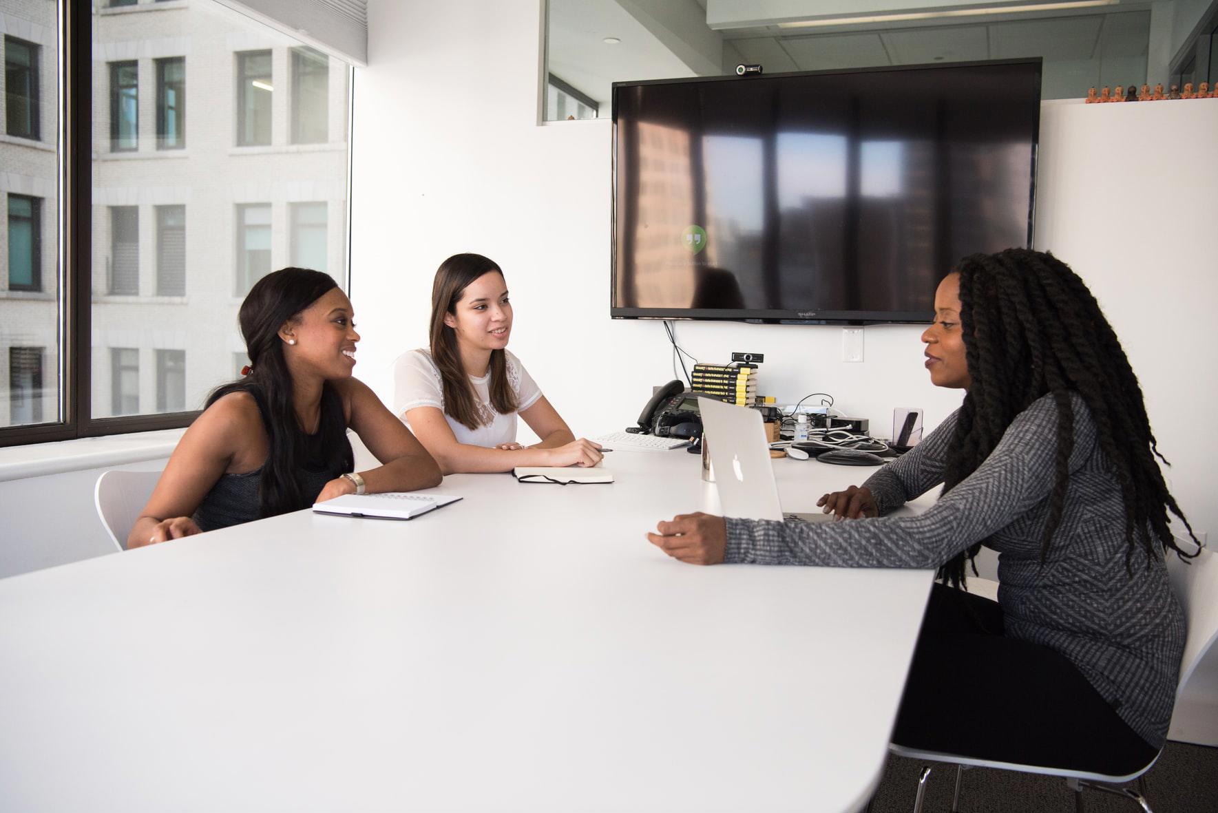 Group of three people in a boardroom