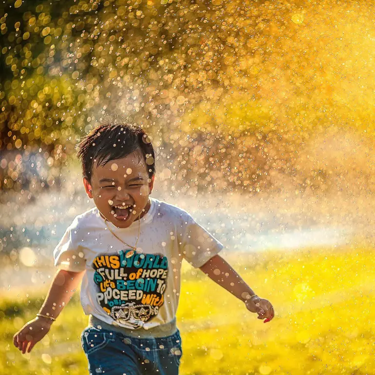 a child running through a water fountain