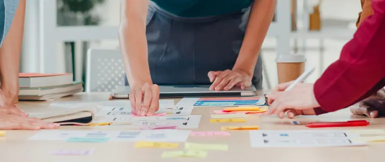 People collaborating at work using post it notes on a table