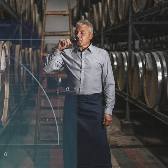 a person sampling a drink from a row of casks