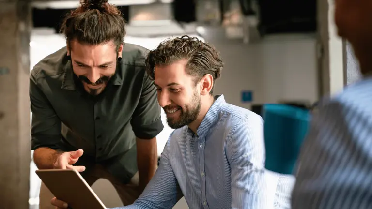 Two people working on a laptop 