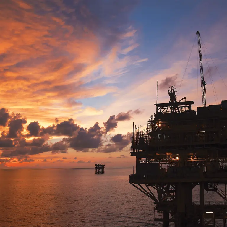 sunset behind oil rig