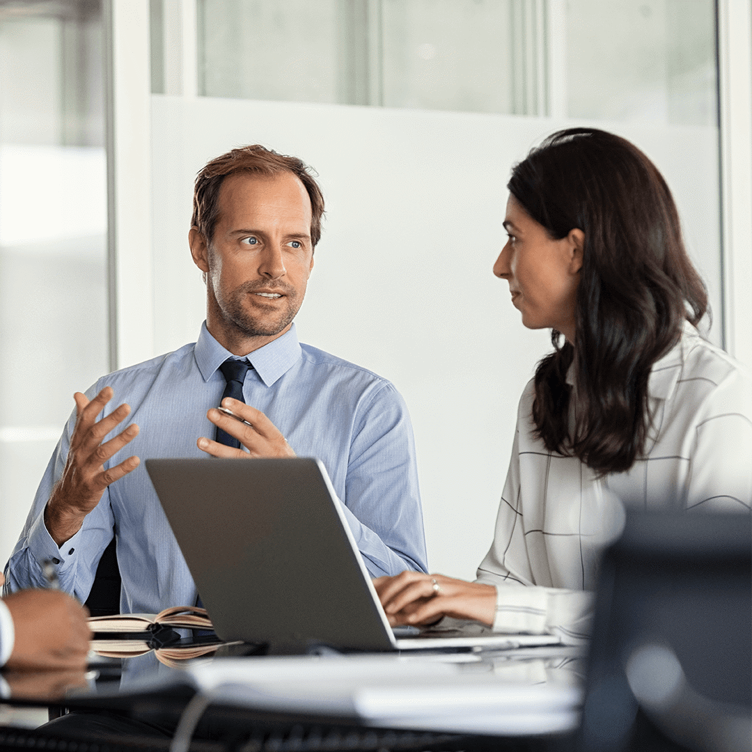 two people in discussion at a desk