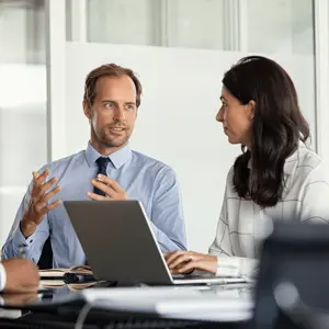 two people in discussion at a desk