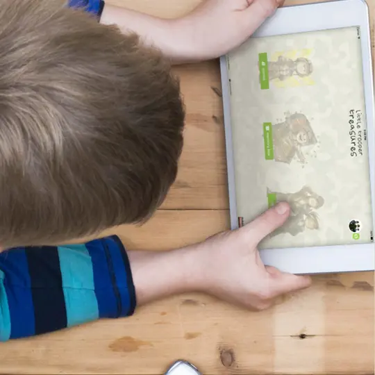 A young child enjoying an interactive story on a tablet screen