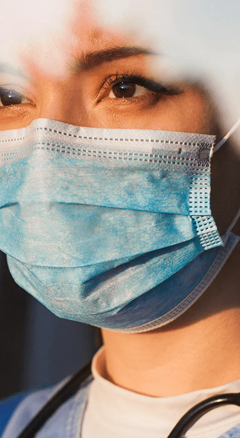 medical professional in surgical mask looking at sunset