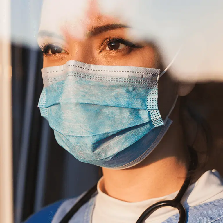 medical professional in surgical mask looking at sunset