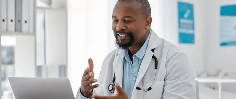 a medical professional taking a remote video call appointment on laptop
