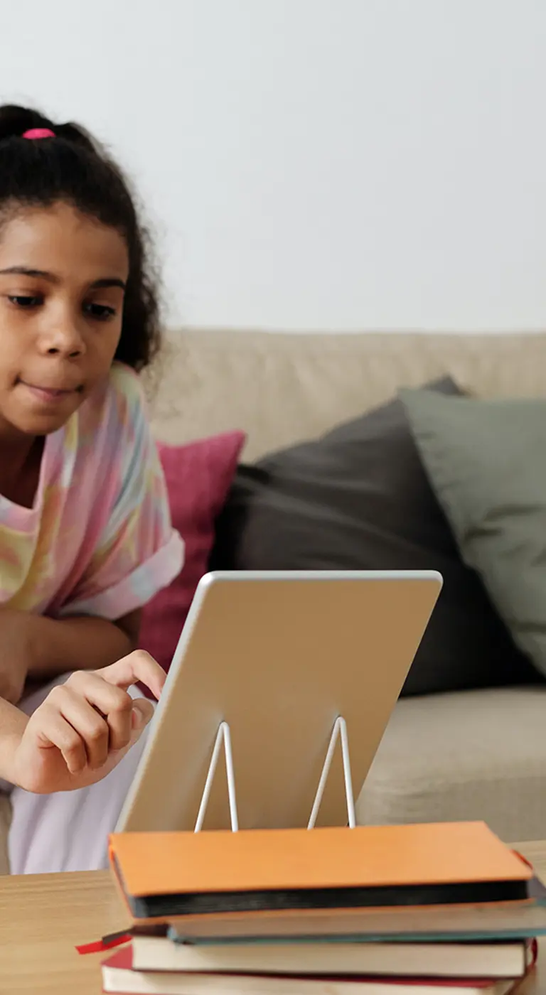 Young girl reading story on tablet device