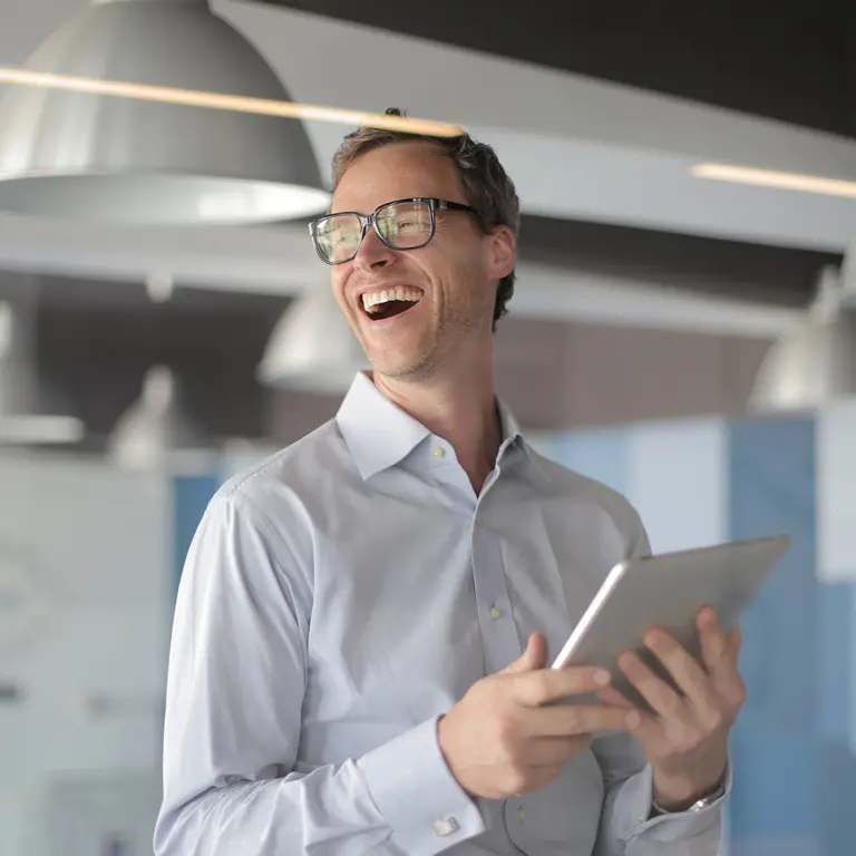 Man laughing with tablet device