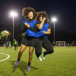 Two young women celebrating on a football field