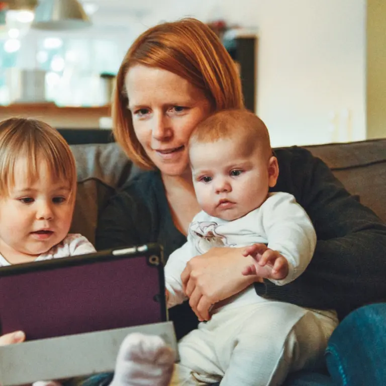 A woman with two young children browsing on a tablet device